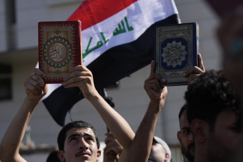 Supporters of the Shiite cleric Muqtada al-Sadr raises of the Quran, the Muslims' holy book, during a demonstration in front of the Swedish embassy in Baghdad in response to the burning of Quran in Sweden, Baghdad, Iraq, Friday, June 30, 2023. (AP Photo/Hadi Mizban)