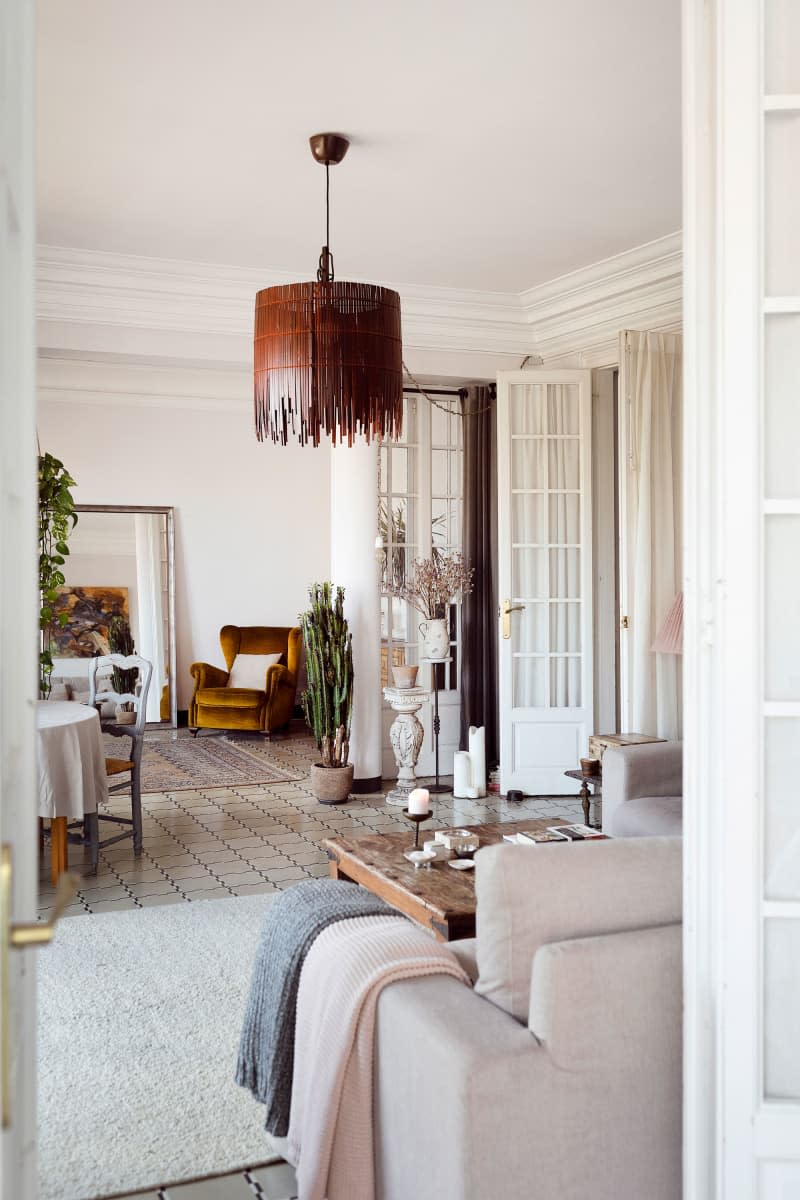 Pendant light hangs in neutral toned living area.