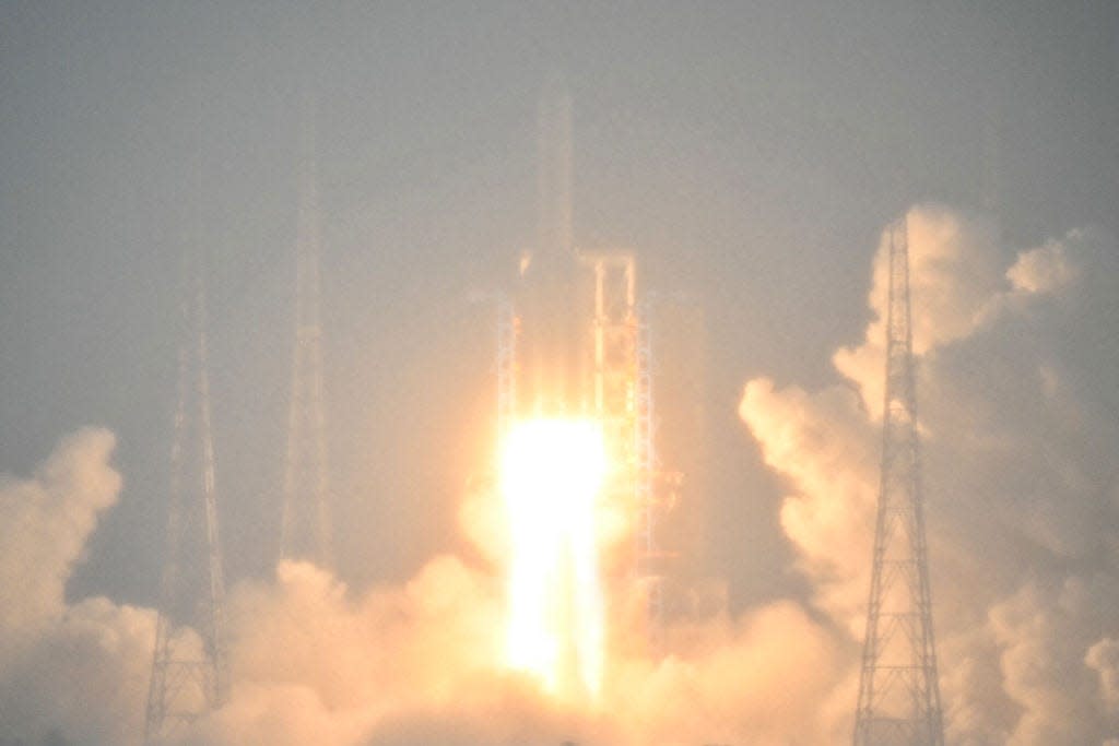 A Long March 5 rocket, carrying the Chang'e-6 mission lunar probe, lifts off as it rains at the Wenchang Space Launch Centre in southern China's Hainan Province on May 3, 2024.