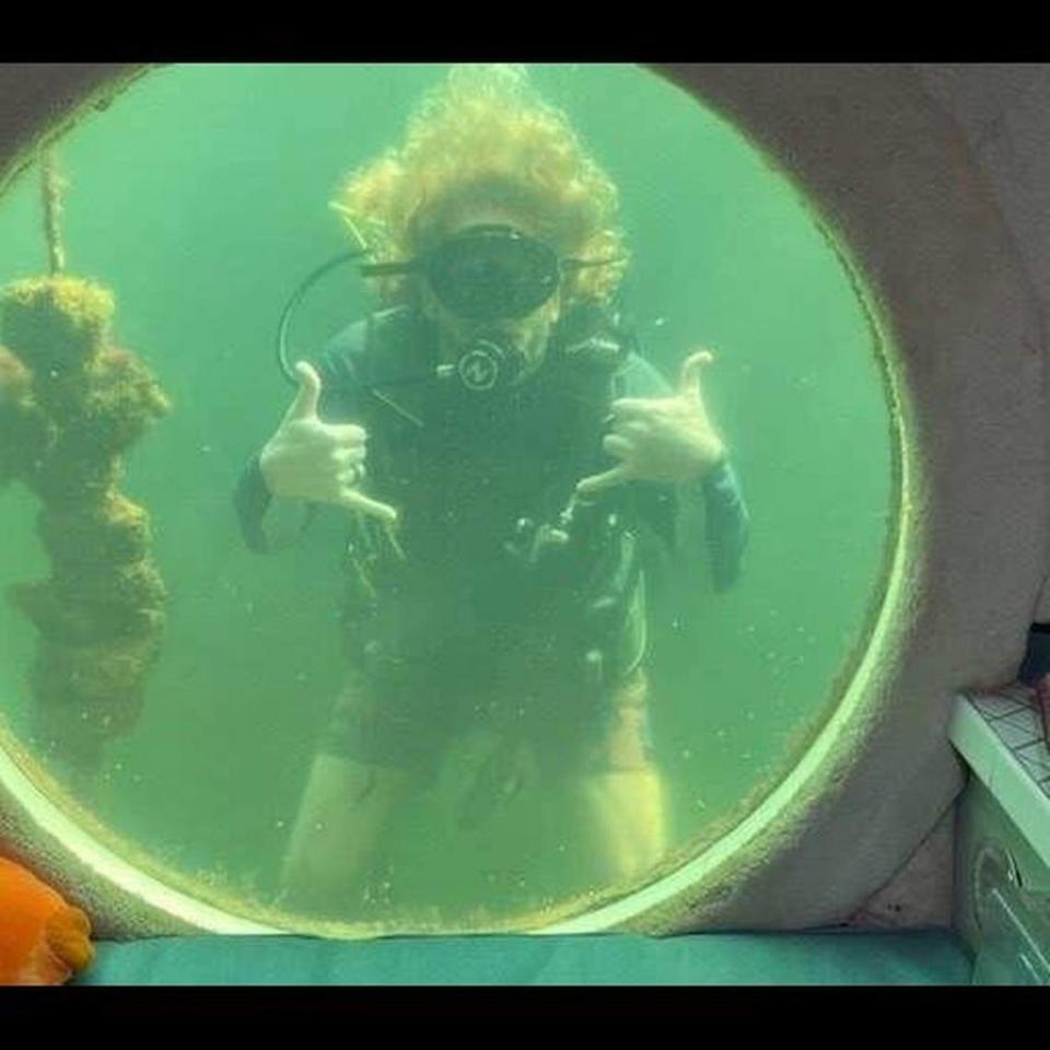 Dr. Joseph Dituri gives the ‘hang loose’ sign while scuba diving outside Jules’ Undersea Lodge in Key Largo.