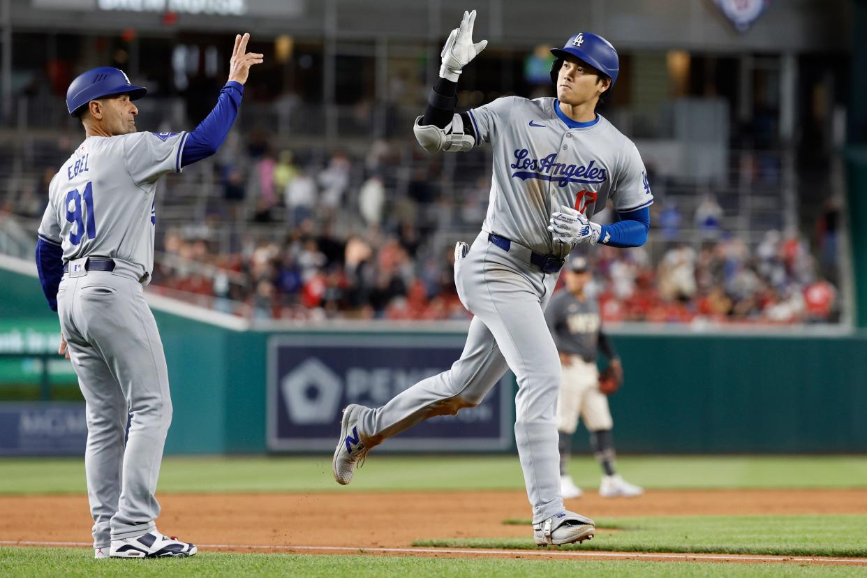 Shohei Ohtani celebrates with third base coach Dino Ebel (91) while rounding the bases after hitting a solo home run against the Washington Nationals.