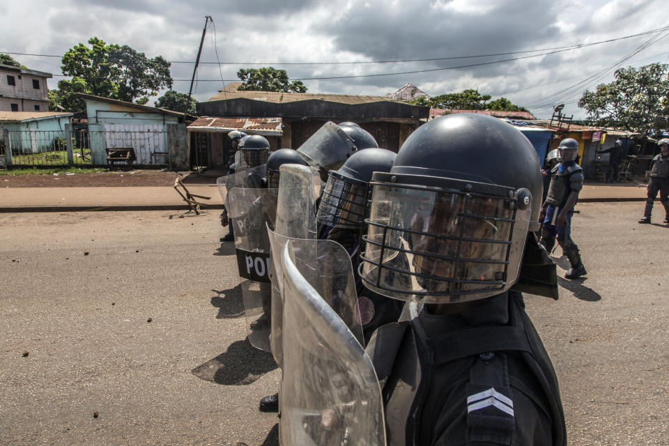 Police face supporters of Guinean opposition leader Cellou Dalein Diallo in Conakry, Guinea, Wednesday, Oct. 21, 2020. Diallo declared himself winner against incumbent President Alpha Conde in Sunday's presidential elections.(AP Photo/Sadak Souici)