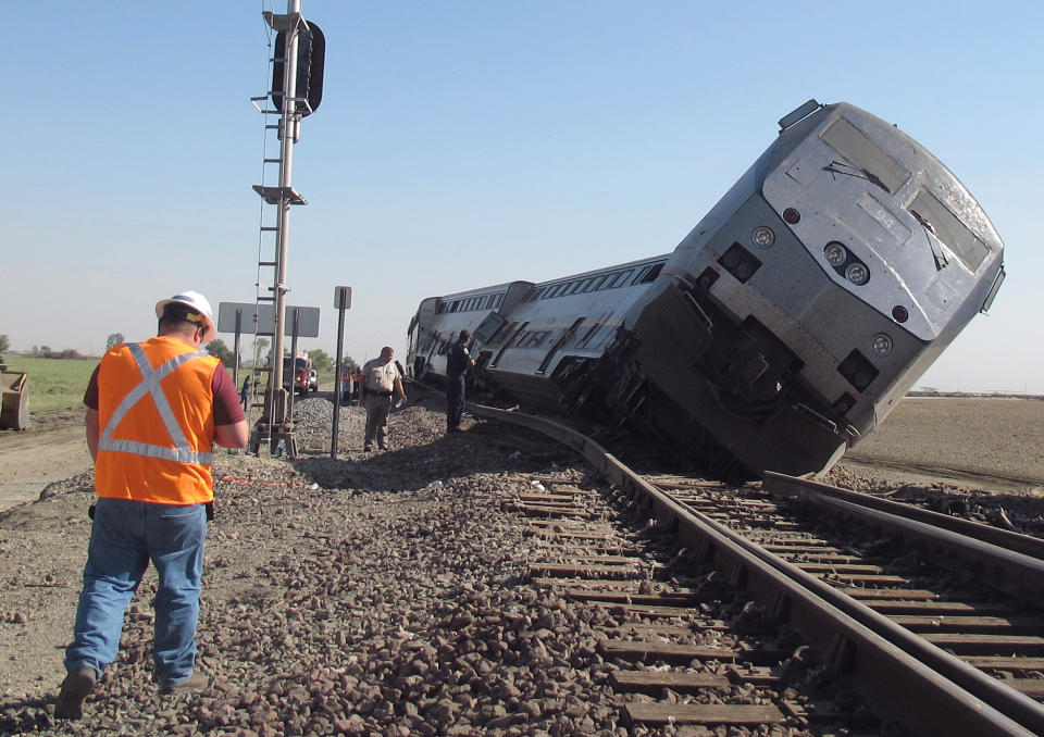 Emergency personnel respond to the scene of a train derailment in Hanford, Calif., Monday, Oct. 1, 2012. Two cars and the locomotive of the train car derailed after colliding with a big rig truck in California's Central Valley, authorities said. At least 20 passengers suffered minor to moderate injuries, authorities said. The crash occurred when the driver of the big rig carrying cotton trash failed to yield and hit the train, authorities said. The impact pushed the two passenger cars and the locomotive off the tracks south of Hanford, a farming town. (AP Photo/Gosia Woznicacka)