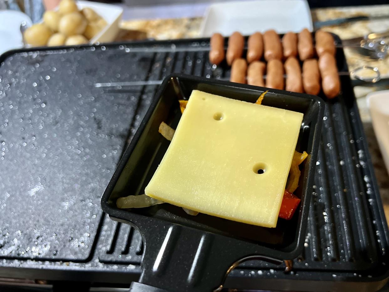 While we grilled miniature sausages, we melted raclette in the lower part of the grill. (Photo: Terri Peters)