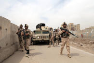 Iraqi security forces guard the main gate of a Shiite private college following a deadly suicide attack, in Baghdad’s eastern neighborhood of Ur, Iraq, Sunday, April 20, 2014. A series of attacks, including a coordinated assault on a private Shiite college in Baghdad, killed over a dozen people and wounded scores of others in Iraq on Sunday, officials said. Less than two weeks ahead of parliamentary elections, Iraq is struggling to keep a lid on a surge in sectarian violence that has sent bloodshed soaring to levels not seen since the country balanced on the brink of civil war in 2006 and 2007. (AP Photo/Khalid Mohammed)