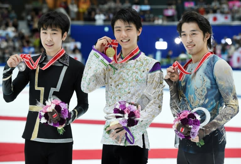 Men's singles winner Yuzuru Hanyu of Japan (C) poses with second placed Jin Boyang of China (L) and third placed Takahito Mura of Japan (R) at the Grand Prix figure skating NHK Trophy in Nagano on November 28, 2015