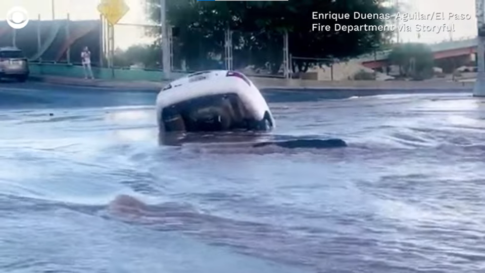 Video showed a flooded sinkhole swallow a woman’s car on a street in El Paso, Texas.