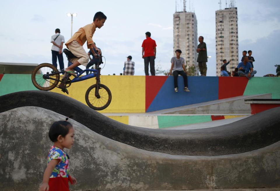 In this Monday, Feb. 13, 2017 photo, children play at Kalijodo Park which is often claimed by the incumbent Jakarta Governor Basuki "Ahok" Tjahaja Purnama who turned the area from a red-light district into a modern skatepark as a legacy of his administration, in Jakarta, Indonesia. Residents of Indonesia's capital vote Wednesday in an election for governor that has become a high-stakes tussle between conservative and moderate forces in the world's most populous Muslim nation. Religion and race, rather than the slew of problems that face a car-clogged and sinking city, have dominated the campaign. (AP Photo/Dita Alangkara)