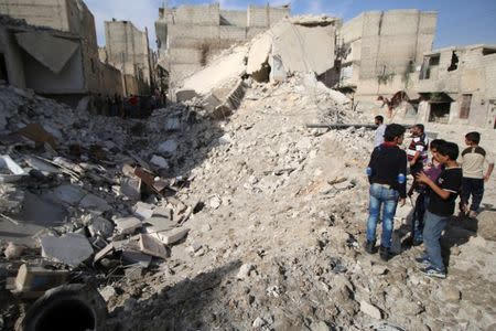 People inspect a damaged site after airstrikes in the rebel held Karam Houmid neighbourhood in Aleppo, Syria October 4, 2016. REUTERS/Abdalrhman Ismail