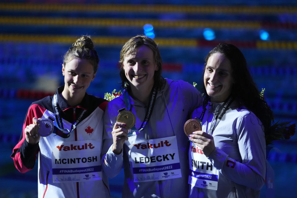 Katie Ledecky of United States, center, Summer Mcintosh of Canada, left, and Leah Smith of United States pose with their medals after the women's 400m freestyle final at the 19th FINA World Championships in Budapest, Hungary, Saturday, June 18, 2022. (AP Photo/Petr David Josek)