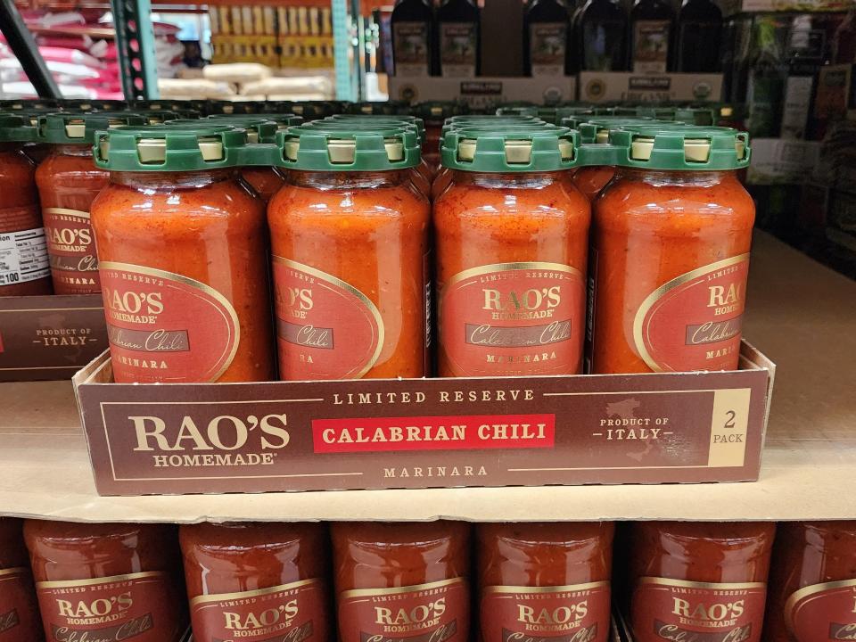 Four jars of Rao's Calabrian chile marinara on a shelf at Costco. The jars are red