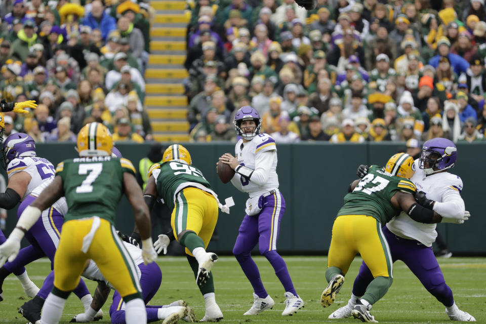 Minnesota Vikings quarterback Kirk Cousins (8), center, looks to pass during the first half of an NFL football game against the Green Bay Packers, Sunday, Oct. 29, 2023, in Green Bay, Wis. (AP Photo/Mike Roemer)