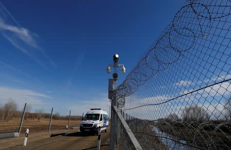 FILE PHOTO: A Hungarian police van passes by an intelligent fence post as it patrols the fortified Hungary-Serbia border near the village of Asotthalom, Hungary March 2, 2017. REUTERS/Laszlo Balogh
