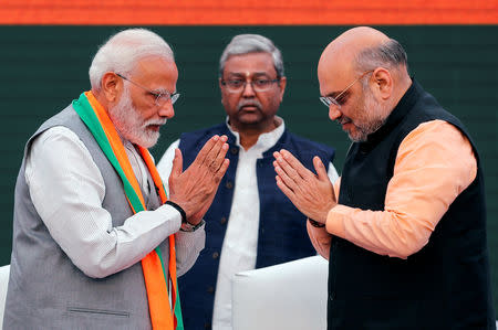 FILE PHOTO: Indian Prime Minister Narendra Modi and chief of India's ruling Bharatiya Janata Party (BJP) Amit Shah, greet each other before releasing their party's election manifesto for the April/May general election in New Delhi, India, April 8, 2019. REUTERS/Adnan Abidi/File Photo