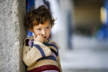 A Kurdish refugee child from the Syrian town of Kobani looks on near makeshift tents in a camp in the southeastern town of Suruc, Sanliurfa province October 26, 2014. REUTERS/Kai Pfaffenbach