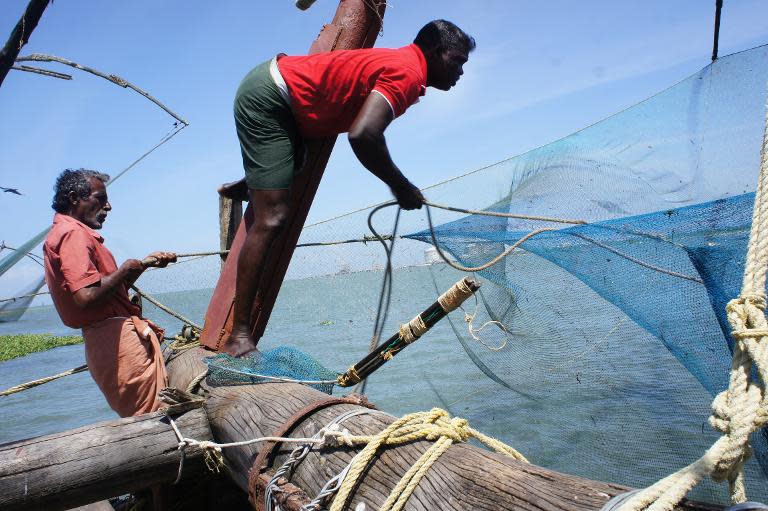 Indian fishermen work on Chinese nets in Kochi, Kerala, on September 13, 2014, but the town now depends on tourists not fish