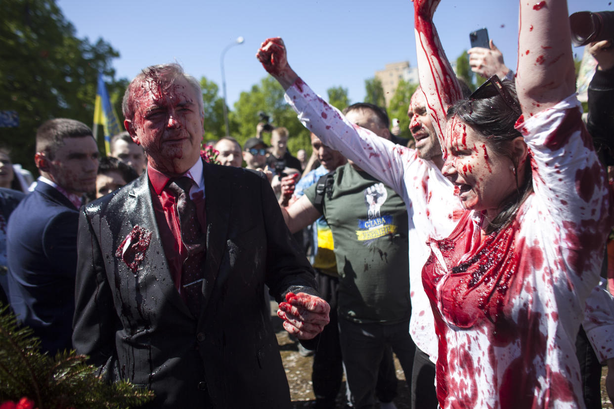 Activists shout slogans as Russian Ambassador to Poland, Ambassador Sergey Andreev, left, is covered with red paint in Warsaw, Poland, Monday, May 9, 2022. Protesters have thrown red paint on the Russian ambassador as he arrived at a cemetery in Warsaw to pay respects to Red Army soldiers who died during World War II. Ambassador Sergey Andreev arrived at the Soviet soldiers cemetery on Monday to lay flowers where a group of activists opposed to Russia’s war in Ukraine were waiting for him. (AP Photo/Maciek Luczniewski)