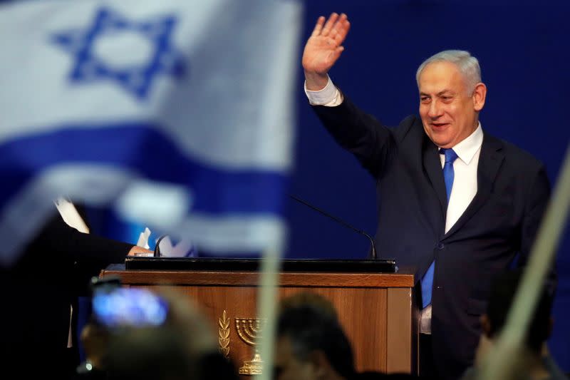 Israeli Prime Minister Benjamin Netanyahu waves to supporters following the announcement of exit polls in Israel's election at his Likud party headquarters in Tel Aviv