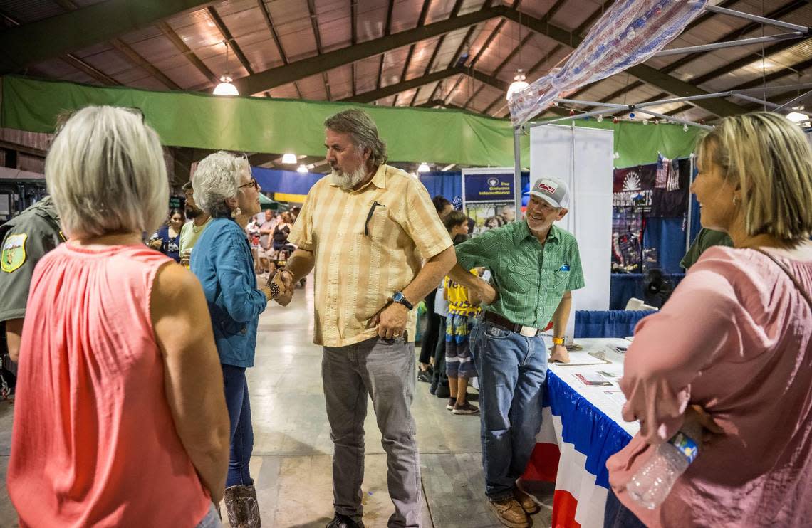 Republican Congressman Doug LaMalfa, center, shakes hands with former Siskiyou County Supervisor Lisa Nixon as other Republicans, elected officials and supporters surround him while he visits the county party’s booth at the Siskiyou Golden Fair in August. Xavier Mascareñas/xmascarenas@sacbee.com