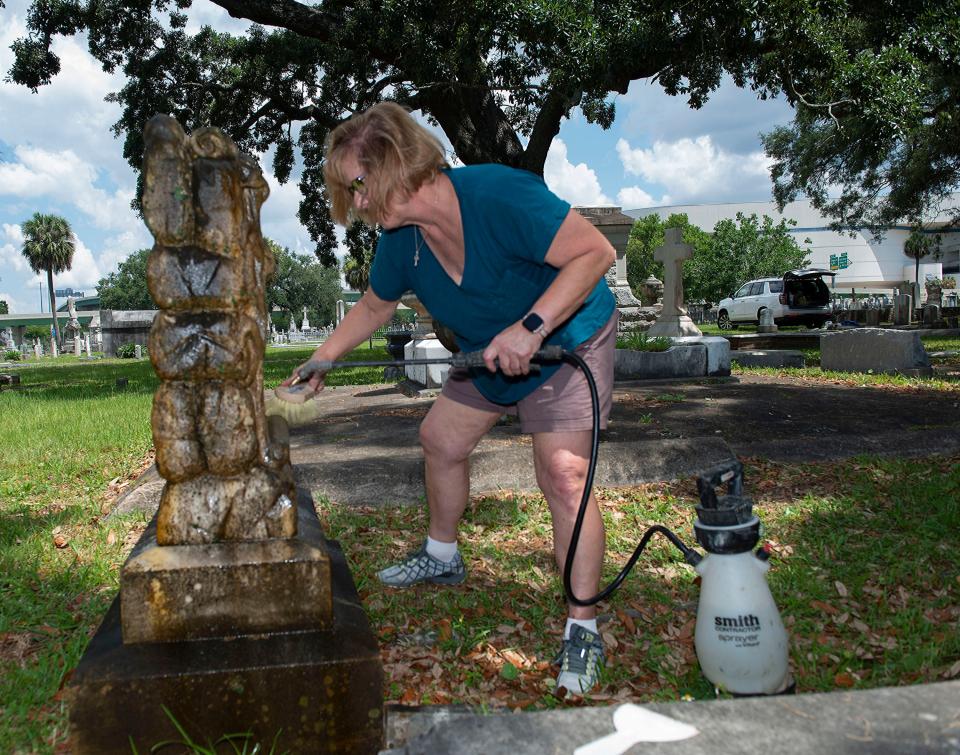 Rachel Burt puts her newfound cleaning skills to the test at St. Michael's Cemetery in Pensacola on Thursday. Burt and other volunteers participated in a workshop at St. Michael's to learn non-destructive ways to clean grave markers.