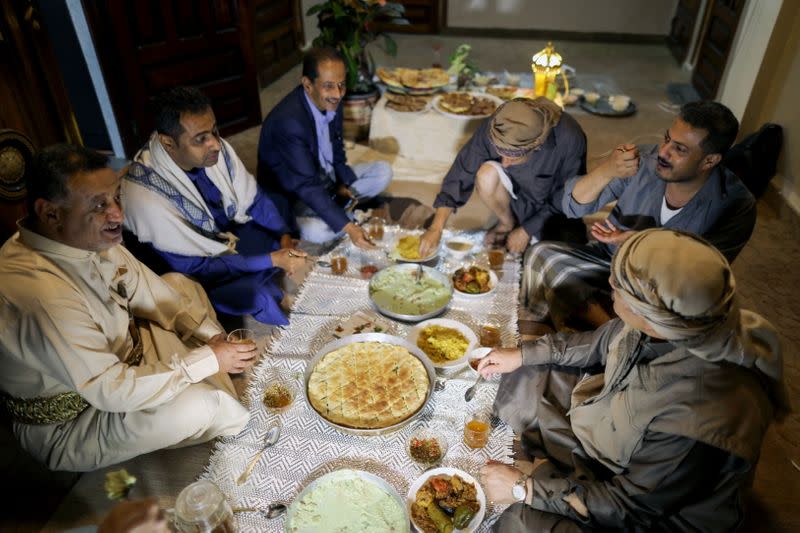 Yemeni singer, Fouad al-Kebsi and his brother Akram, sit with guests for the iftar meal at their family house during the holy month of Ramadan in Sanaa