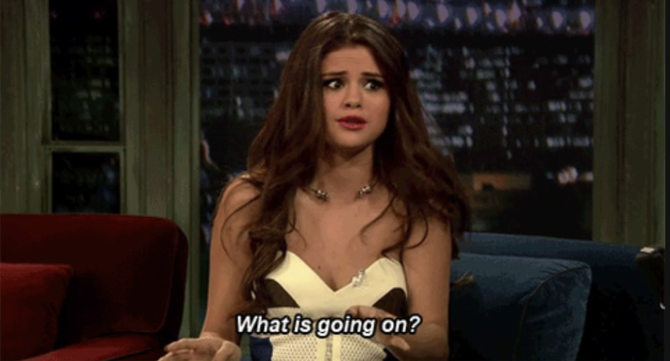 Selena Gomez sitting on a couch looking confused with the caption "What is going on?"