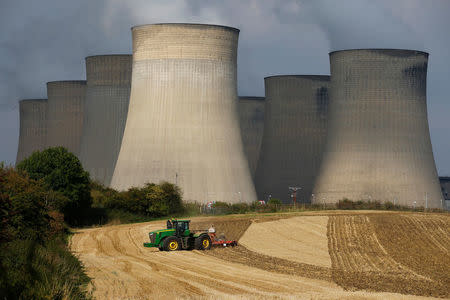 FILE PHOTO: A farmer works a field in the shadows of Ratcliffe-on-Soar Power Station, Britain, September 10, 2014. REUTERS/Darren Staples/File Photo