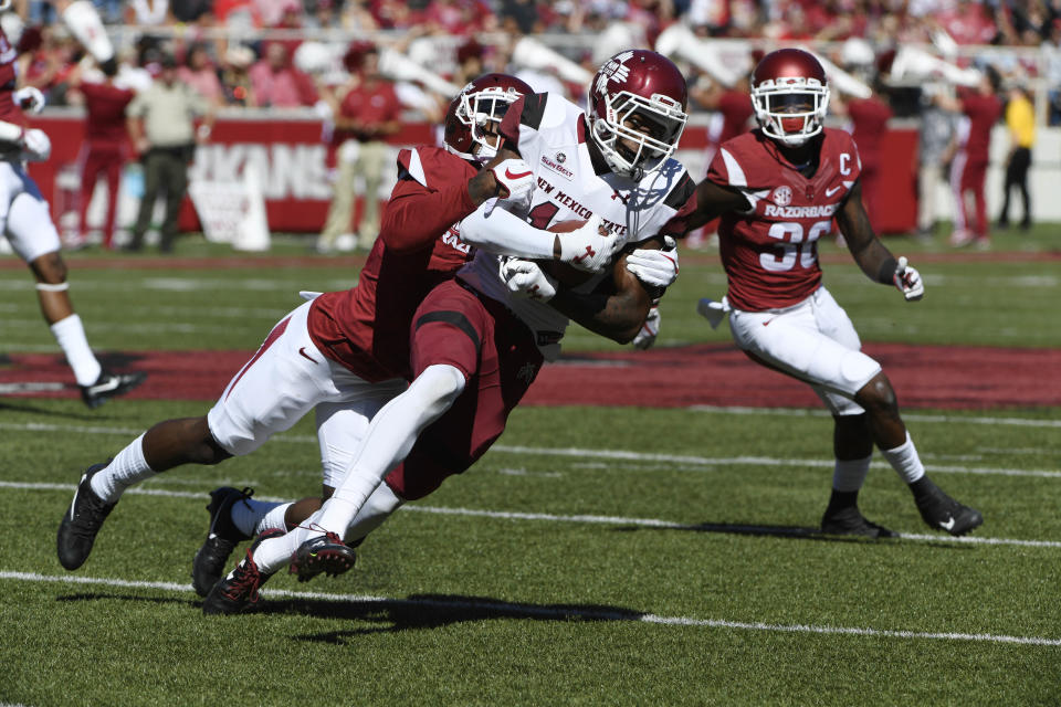 Arkansas defender Kamren Curl tackles New Mexico State receiver Jaleel Scott in the first half of an NCAA college football game in Fayetteville, Ark., Saturday, Sept. 30, 2017. Arkansas won the game 42-24. (AP Photo/Michael Woods)