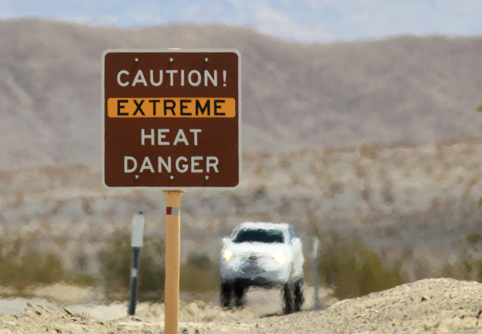 Heat waves rise near a heat danger warning sign in Death Valley National Park, California.  / Credit: David McNew / Getty Images
