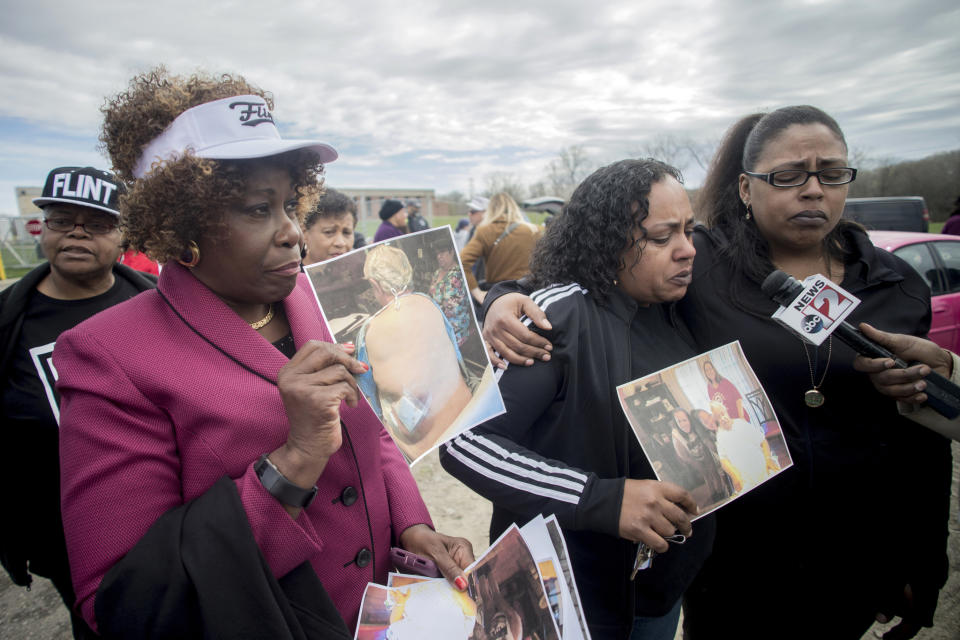 Detroit attorney Cynthia M. Lindsey stands alongside her clients Buffi Clements, 42 at center, and her sister Brandi as they talk about the death of their father Joseph C. Clements, who passed away from kidney cancer in July 2017 during a rally on the five-year anniversary of the Flint water crisis on Thursday, April 25, 2019 outside of the Flint, Mich., water plant. Buffi Clements said their family believes his cancer was caused by drinking Flint tap water following the switch, and are currently part of a class action lawsuit. (Jake May/MLive.com/The Flint Journal via AP)