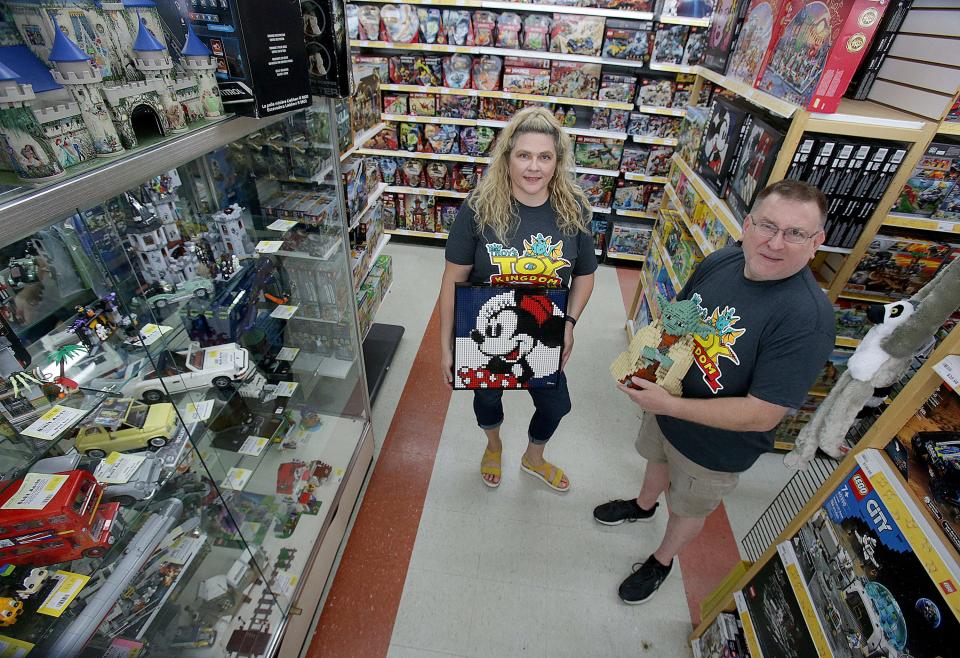 Troy Cefratti, owner of Sir Troy’s Toy Kingdom, and Heather Marks, vice president of Sir Troy’s, pose with some of the Lego displays at the North Canton toy store in this file photo.