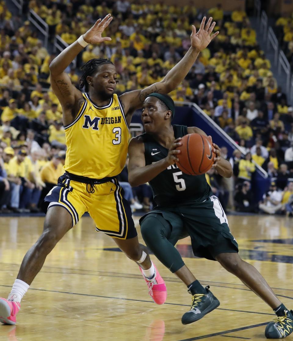 Michigan State guard Cassius Winston (5) drives on Michigan guard Zavier Simpson (3) during the second half of an NCAA college basketball game, Sunday, Feb. 24, 2019, in Ann Arbor, Mich. (AP Photo/Carlos Osorio)
