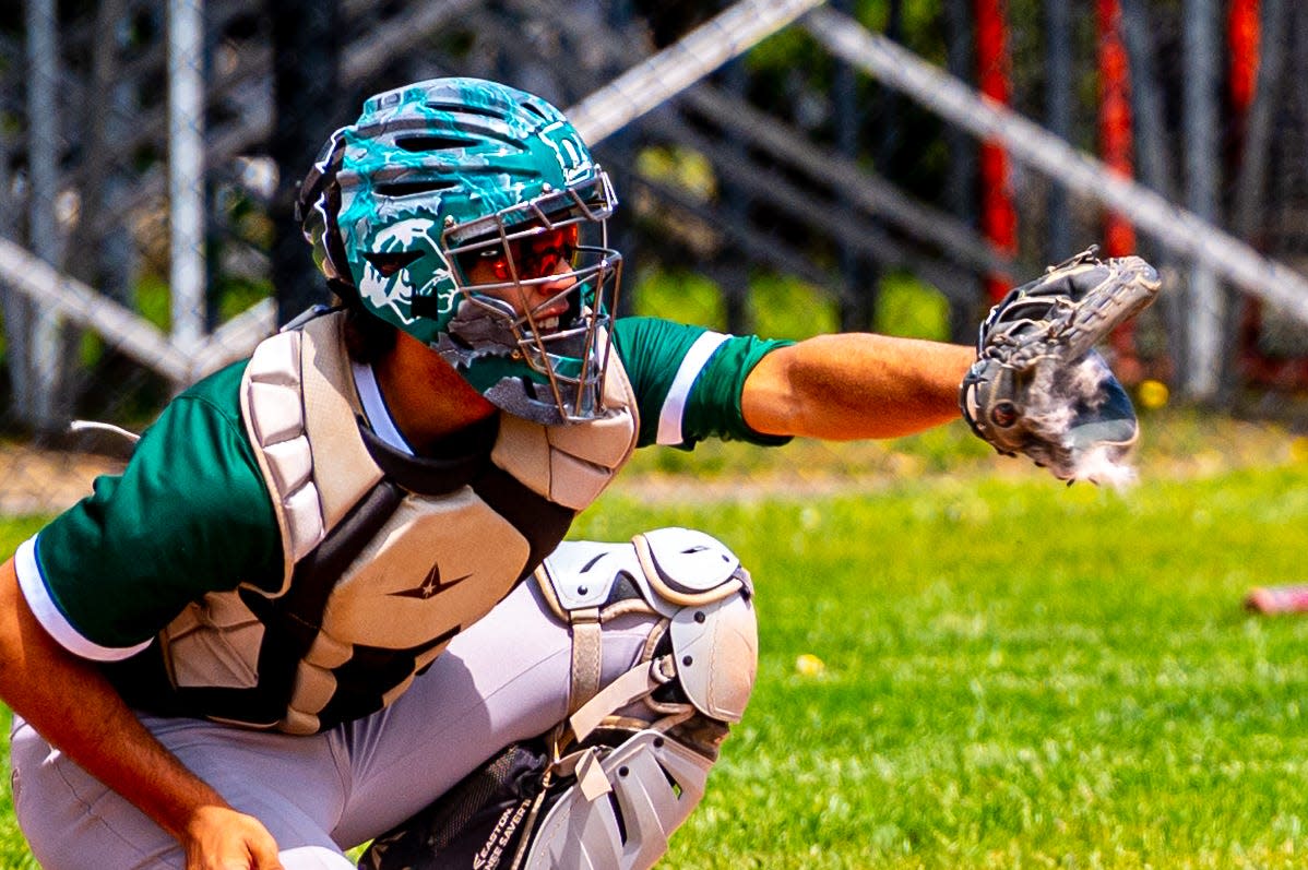 With a cloud of dirt coming from the glove, Dartmouth's Donovan Burgo frames the pitch.