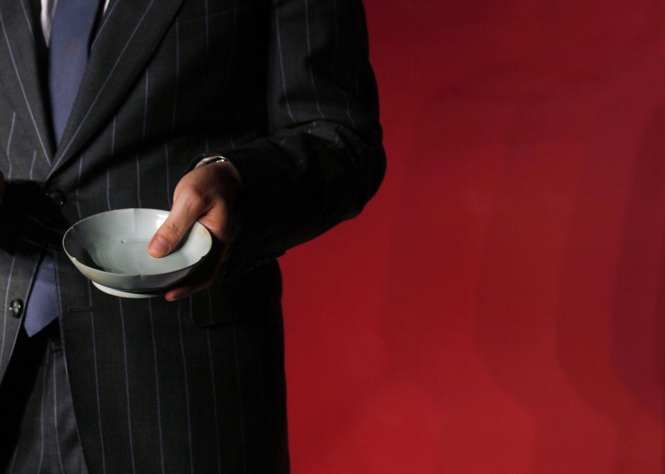 Nicolas Chow, Sotheby’s Asia Deputy Chairman, holds the Chinese Song Dynasty ceramics Ruyao Washer at the Sotheby's auction in Hong Kong Wednesday, April 4, 2012. The 900-year-old dish smashed the world record for Chinese Song Dynasty ceramics sold at auction, fetching US$26.7 million. (AP Photo/Kin Cheung)