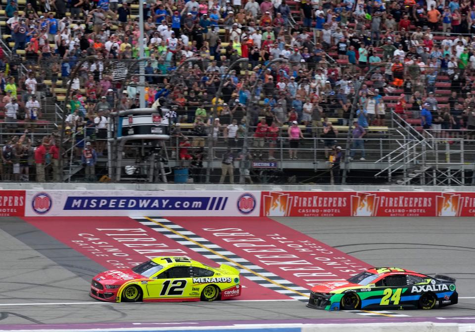 Ryan Blaney (12) takes the checkered flag ahead of William Byron (24) during the 2021 FireKeepers Casino 400 at Michigan International Speedway.