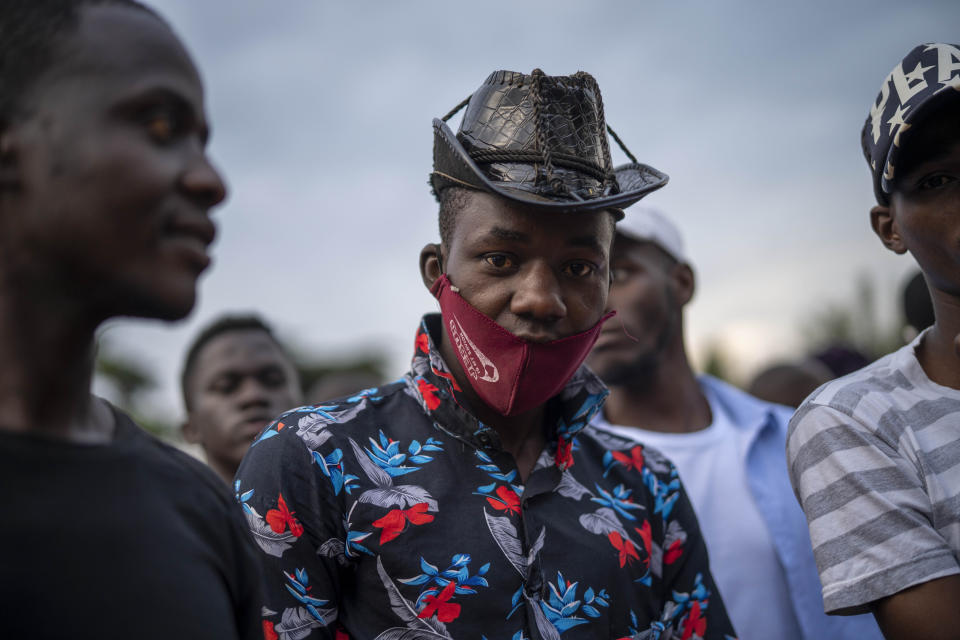 Ugandans wait to vote in Kampala, Uganda, Thursday, Jan. 14, 2021. Ugandans are voting in a presidential election tainted by widespread violence that some fear could escalate as security forces try to stop supporters of leading opposition challenger BobiWine from monitoring polling stations.(AP Photo/Jerome Delay)