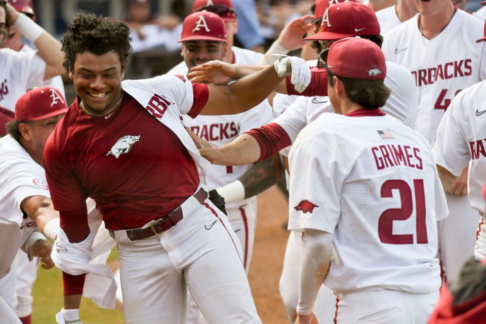 Arkansas batter Kendall Diggs celebrates with teammates after hitting the walk-off solo homer in extra innings to down Texas A&M 6-5 during the second round of the SEC Baseball Tournament at the Hoover Met Wednesday, May 24, 2023.