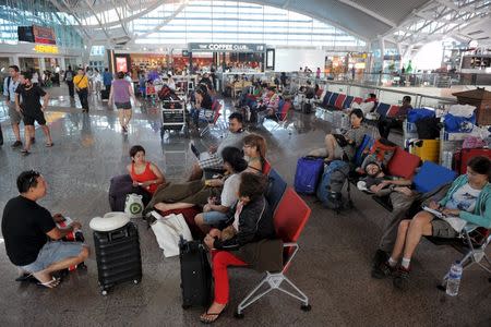 Passengers spend their time at a waiting room as all flights are cancelled at the Ngurah Rai airport in Bali, November 4, 2015 in this picture taken by Antara Foto. REUTERS/Nyoman Budhiana/Antara Foto