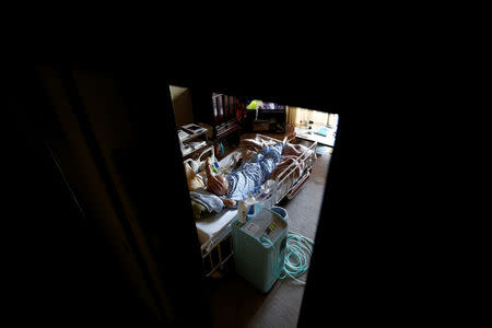 Yasuhiro Sato, 75, who has terminal lung cancer, rests on a bed at his home in Tokyo, Japan, July 11, 2017. REUTERS/Kim Kyung-Hoon