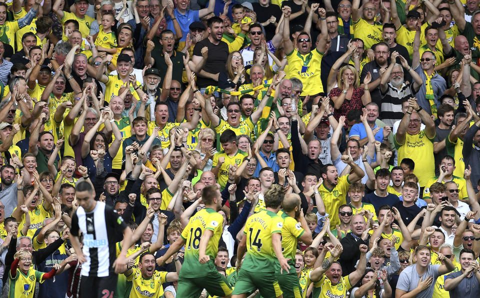 Norwich City's Teemu Pukki celebrates scoring his side's first goal of the game with fans, during the English Premier League soccer match between Norwich City and Newcastle United, at Carrow Road, in Norwich, England, Saturday, Aug.17, 2019. (Joe Giddens/PA via AP)