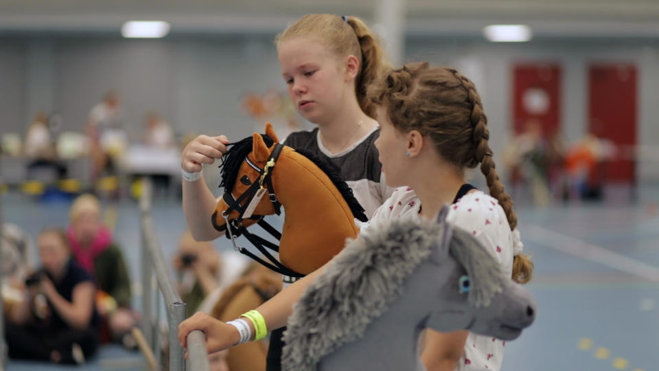 Young hobby horse competitors care for their toy horses in Seinajoki, Finland, on Saturday, June 15, 2019. More than 400 hobby horse enthusiasts took part in Finland's 8th Hobby Horse championships, competing on stylish toy horses in various events inspired by real equestrian events. (AP Photo/from APTN Video)