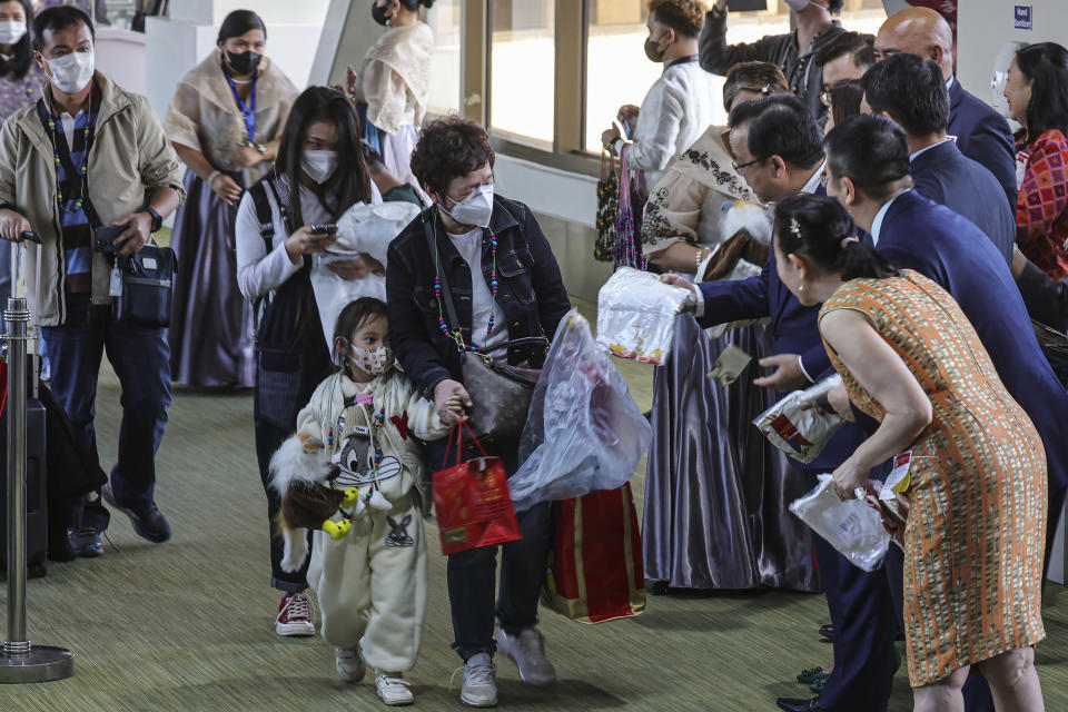 Chinese Ambassador to the Philippines Huang Xilian, partly hidden, and Philippine Department of Tourism Secretary Cristina Frasco welcome the Chinese nationals arriving at the Ninoy Aquino International Airport in Manila on Tuesday, Jan. 24, 2023. The expected resumption of group tours from China is likely to bring far more visitors. (AP Photo/Gerard V. Carreon)