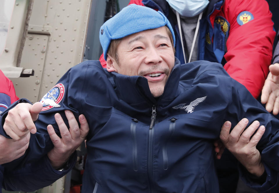 Space flight participant Japanese entrepreneur Yusaku Maezawa is assisted as he disembarks from a helicopter as he arrives at airport after returning from the International Space Station on the Soyuz MS-20 space capsule, in Zhezkazgan, Kazakhstan, Monday, Dec. 20, 2021. A Japanese billionaire, his producer and a Russian cosmonaut safely returned to Earth on Monday after spending 12 days on the International Space Station. (Shamil Zhumatov/Pool Photo via AP)