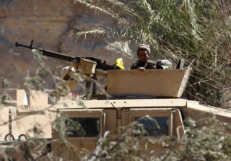 A fighter of Syrian Democratic Forces is seen on a military vehicle in the village of Baghouz, Deir Al Zor province, Syria, March 18, 2019. REUTERS/Stringer