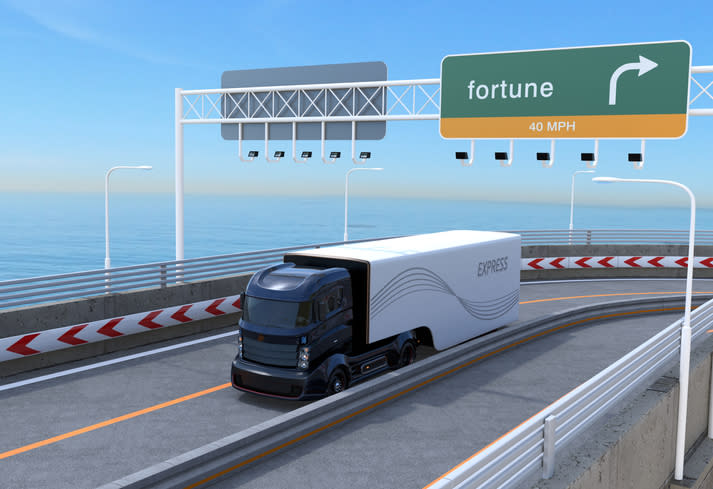 Artist's rendering of an autonomous tractor-trailer traveling on a highway adjacent to a body of water with blue sky in background.