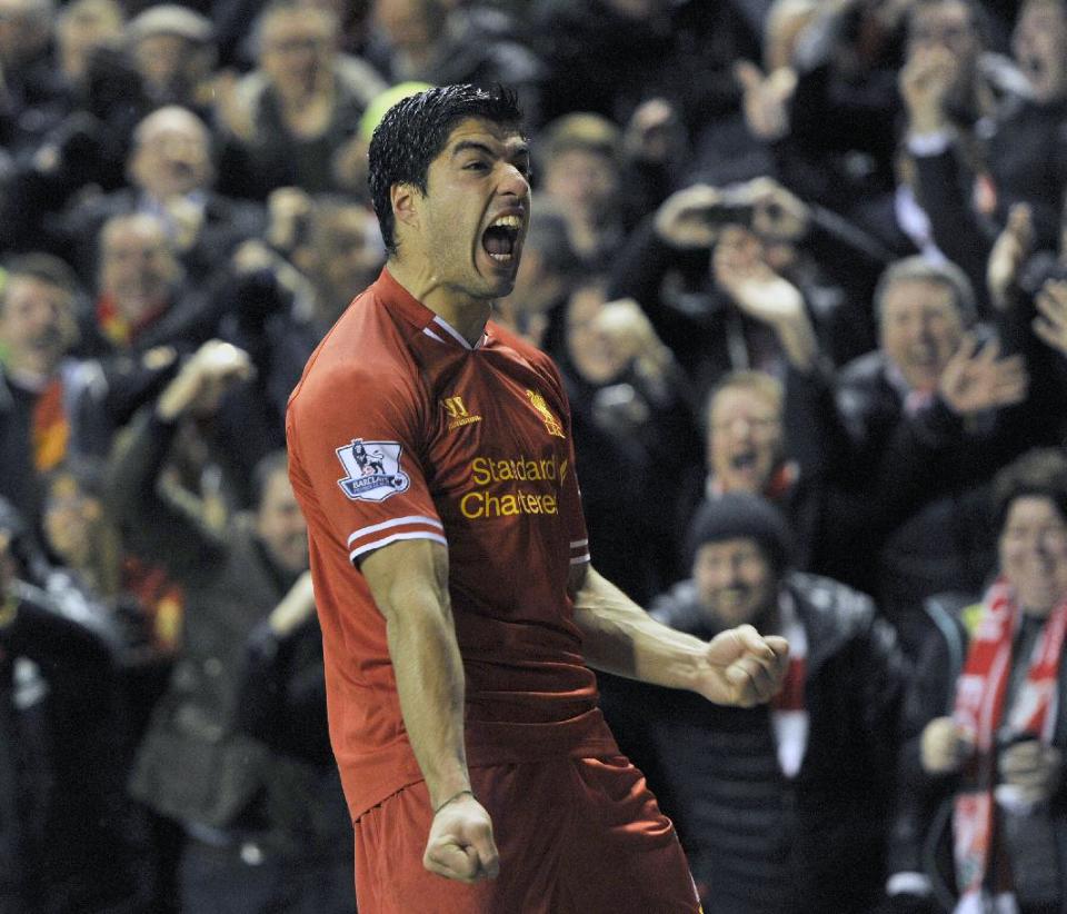 Liverpool's Luis Suarez celebrates after he scores the fourth goal of the game for his side during their English Premier League soccer match against Everton at Anfield in Liverpool, England, Tuesday Jan. 28, 2014. (AP Photo/Clint Hughes)