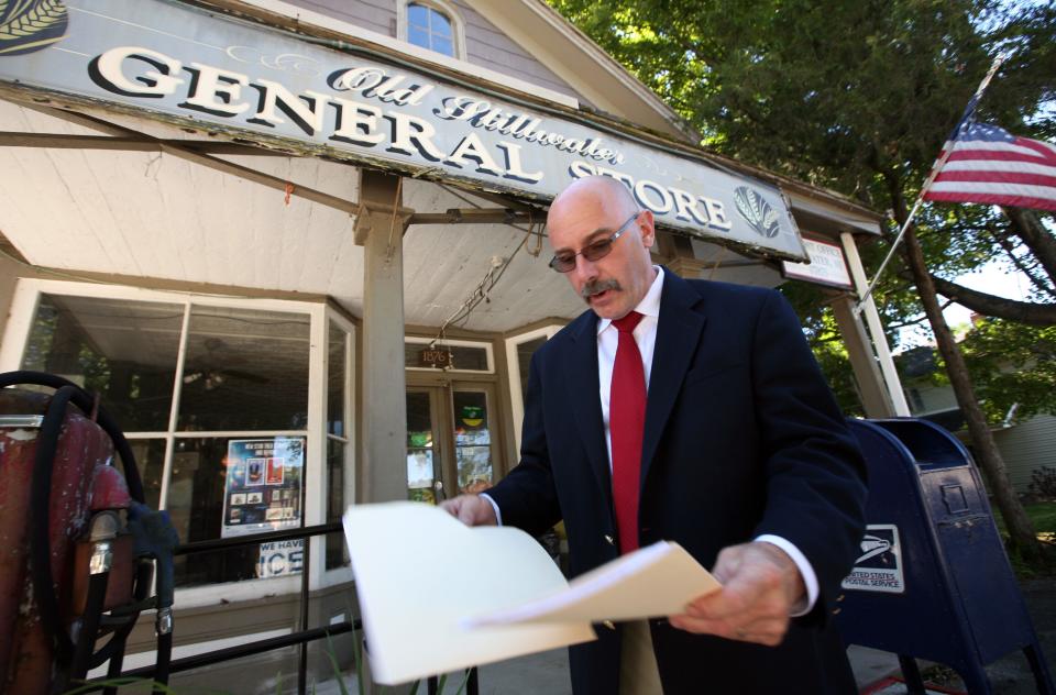 Dean Voris looks over folders of papers documenting the history of the Garris General Store while outside the store's front entrance in Stillwater Monday, Aug. 29, 2016.