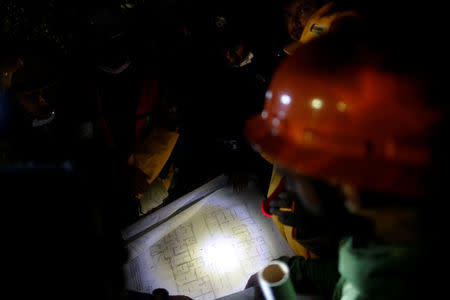 Rescue worker and Mexican soldiers study the drawing of a collapsed building as they search for survivors after an earthquake in Mexico City, Mexico September 21, 2017. REUTERS/Carlos Jasso