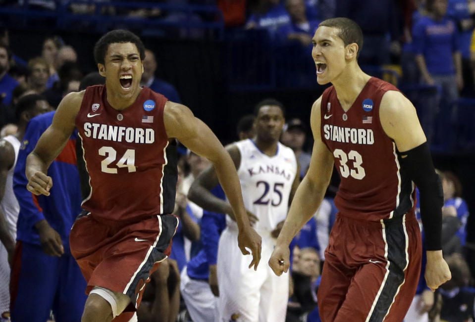 Stanford's Josh Huestis, left, and Dwight Powell, right, celebrate as Kansas' Tarik Black (25) watches in the background after in a third-round game of the NCAA college basketball tournament Sunday, March 23, 2014, in St. Louis. Stanford won 60-57. (AP Photo/Jeff Roberson)