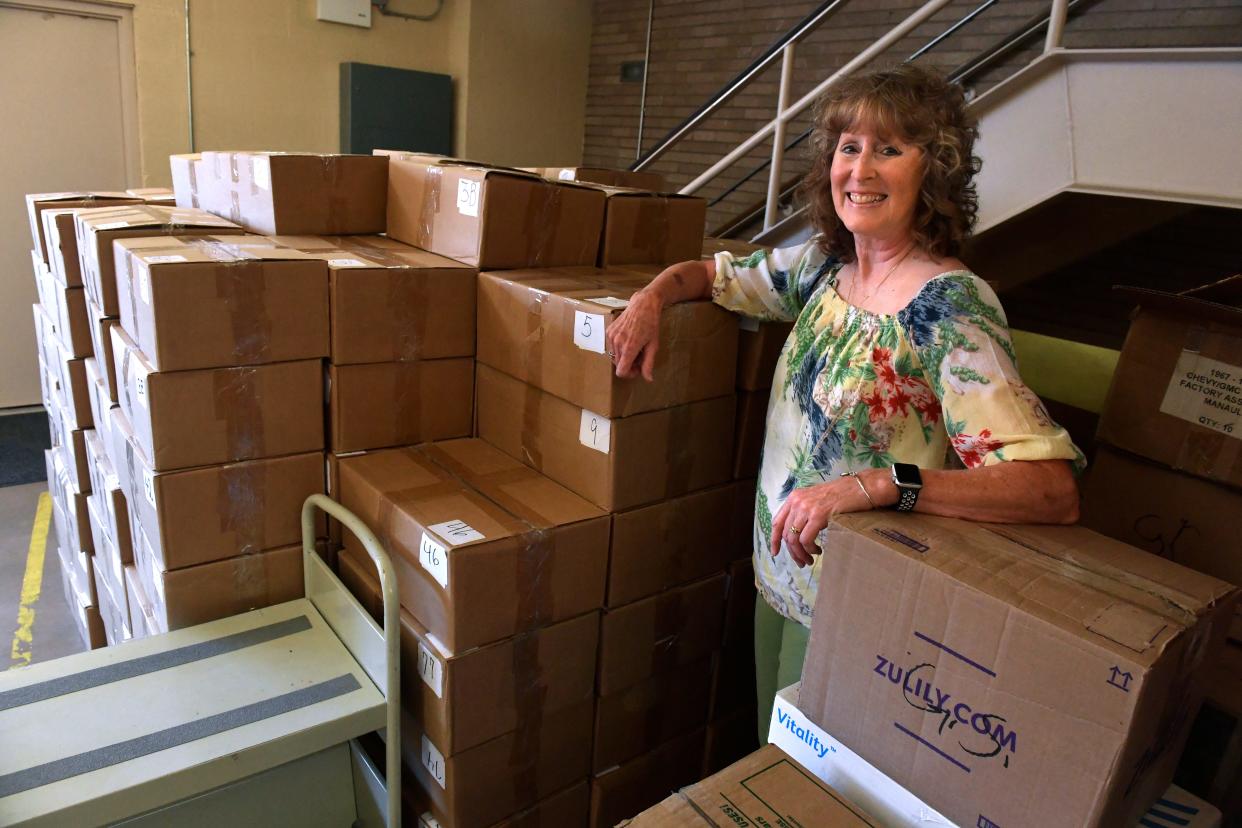 Karrie Partin, a volunteer with the Friends of the Abilene Public Library, stands Friday with some of the books which will be offered for the group's annual book sale. Partin retired as a teacher from the Abilene Independent School District this year.